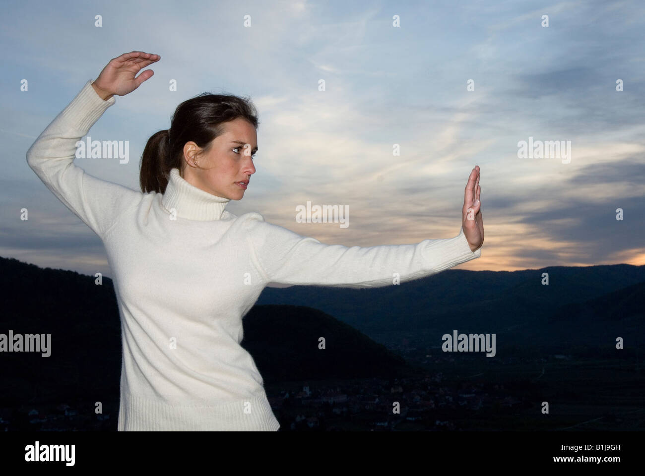 Junge Frau praktizieren Tai Chi auf einem Berg Stockfoto