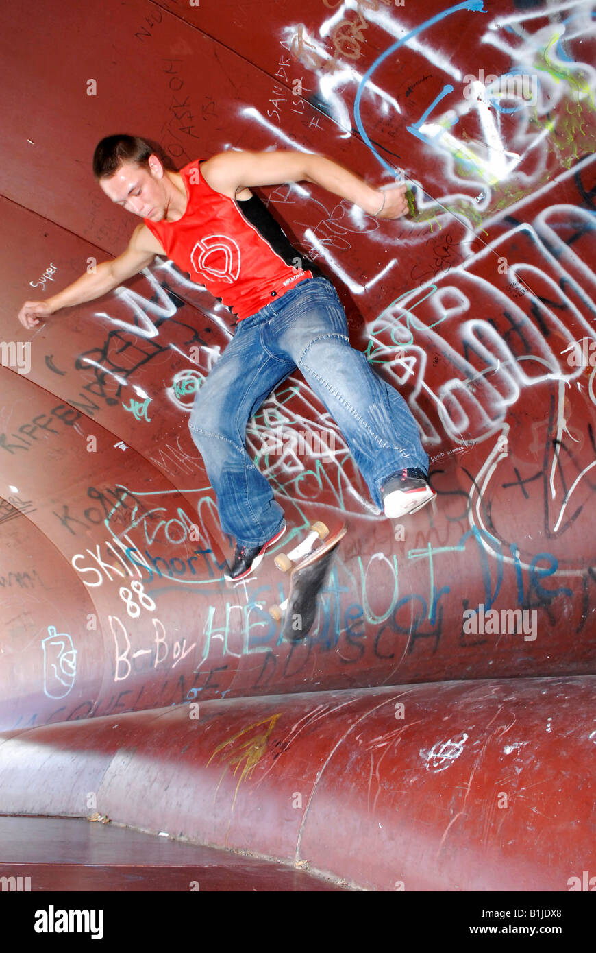 männlichen Teenager mit seinem Skateboard springen Stockfoto