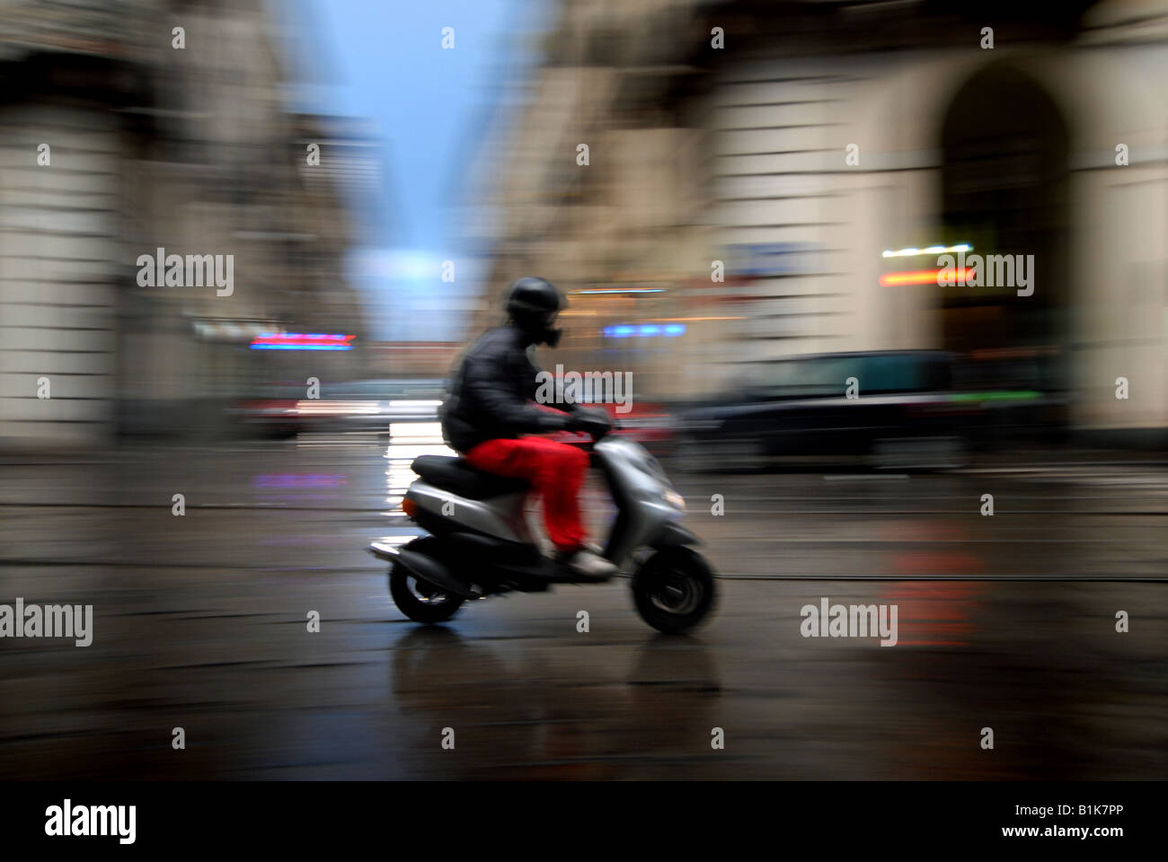 Ein Roller fährt durch den Regen entlang Via Po in Turin, Piemont, Italien. Stockfoto