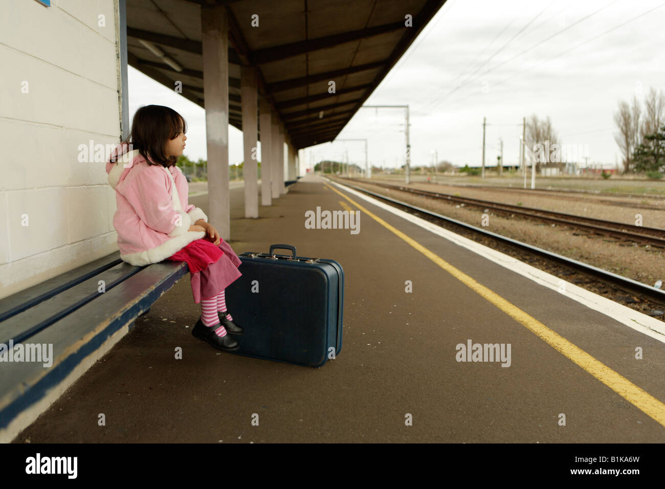 Mädchen im Alter von vier wartet auf den Zug auf der Plattform am Bahnhof von Palmerston North New Zealand Stockfoto