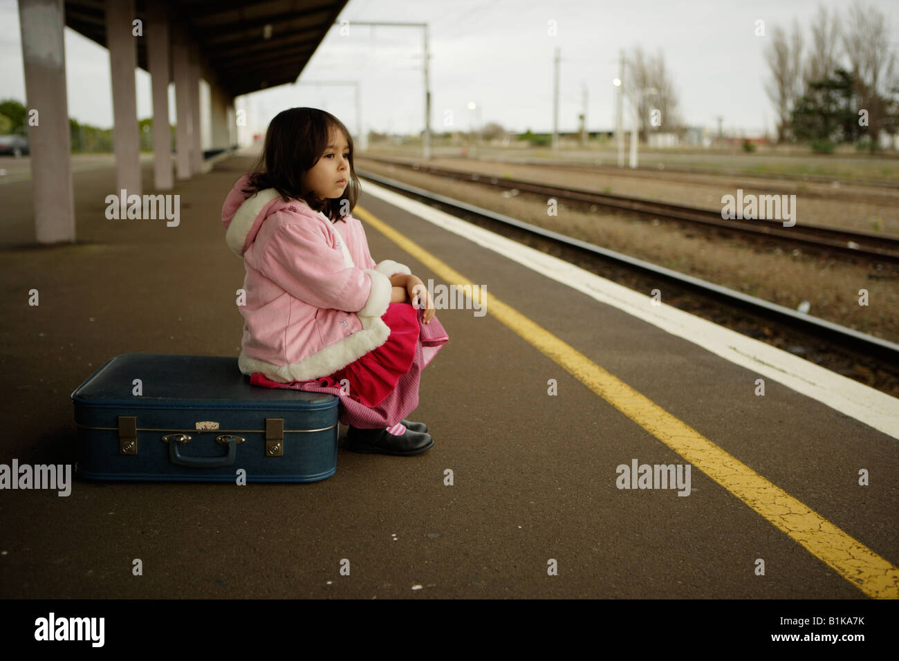 Mädchen im Alter von vier wartet auf den Zug auf der Plattform am Bahnhof von Palmerston North New Zealand Stockfoto