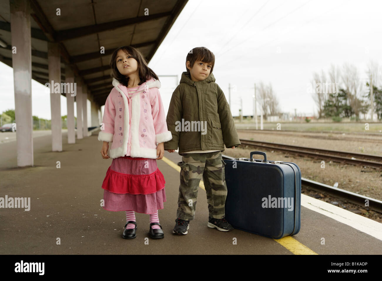 Jungen im Alter von sechs und Schwester im Alter von vier warten auf den Zug auf der Plattform am Bahnhof von Palmerston North New Zealand Stockfoto