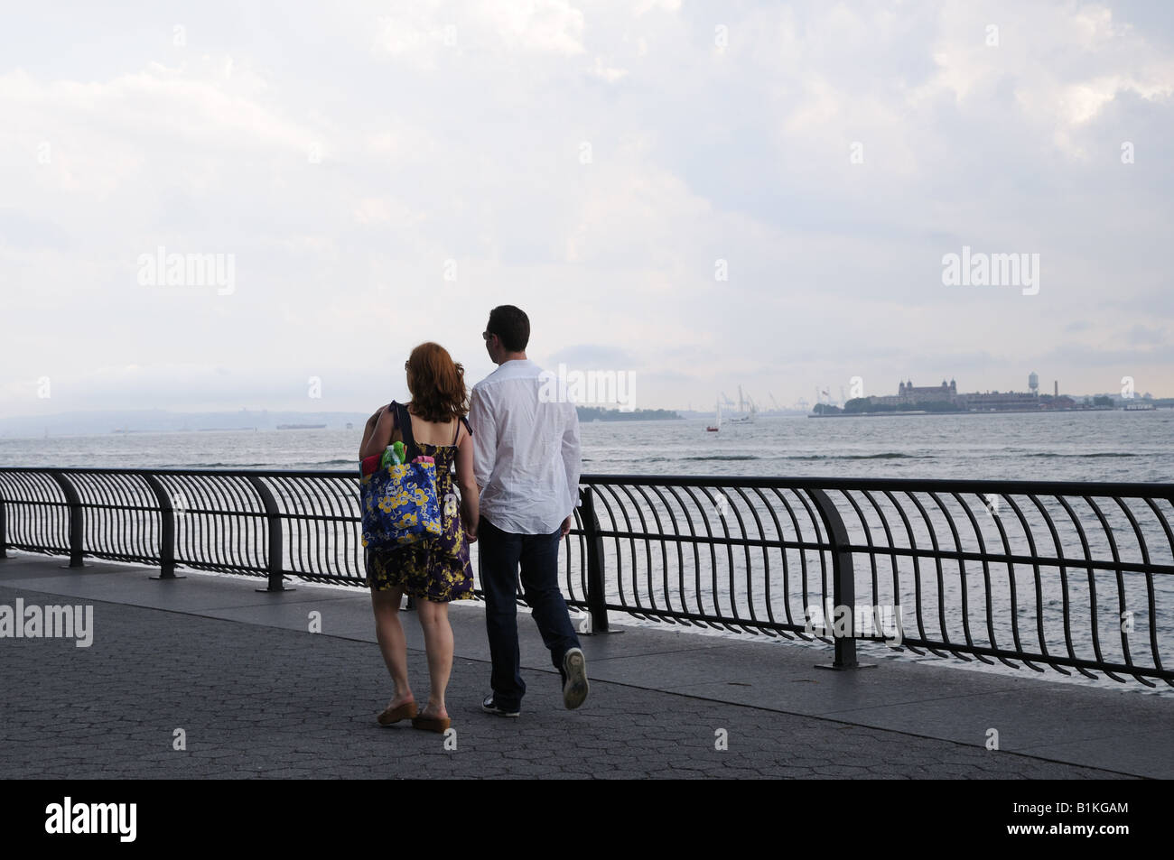 Ein paar Spaziergänge entlang der Promenade von Battery Park City an einem regnerischen Tag. Stockfoto