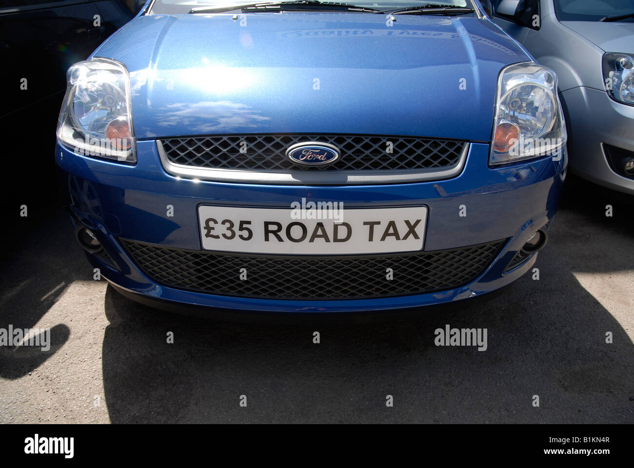 Eine Werbung die niedrige Rate der Kfz-Steuer nach den neuen Vorschriften der UKs Lizenz diensthabenden Fahrzeug Ford-Fahrzeug Stockfoto