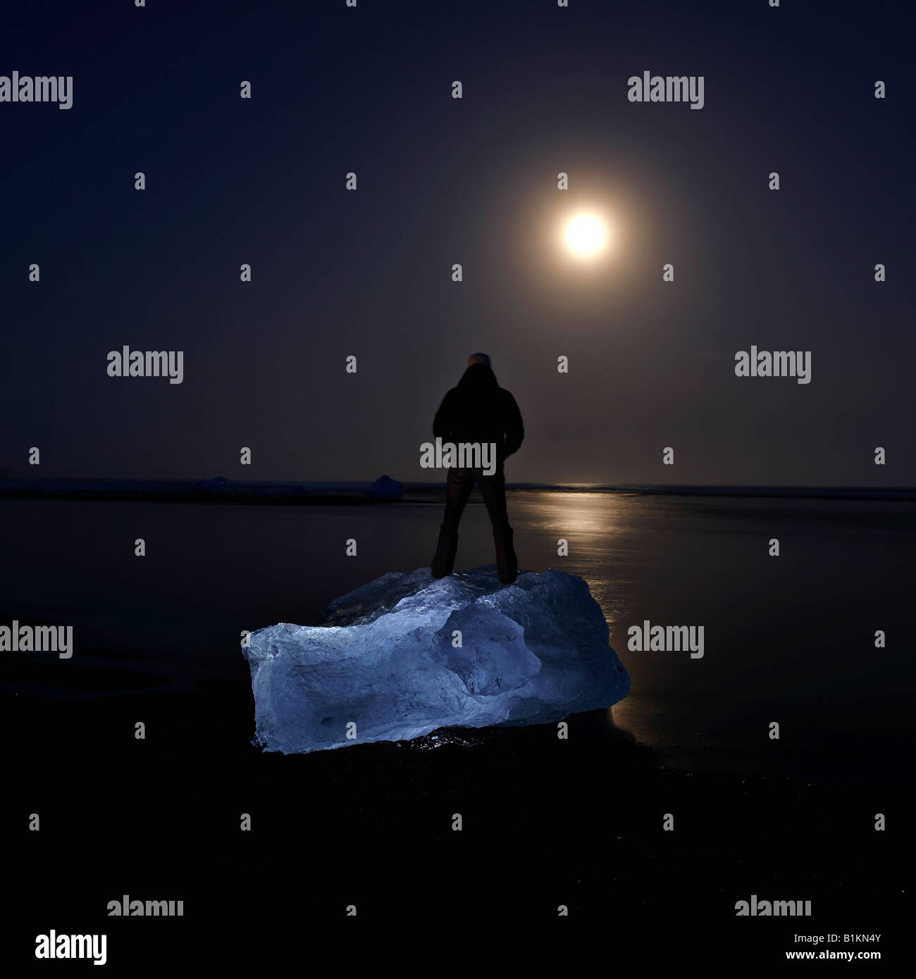 Mann steht auf einem Gletscher um Mitternacht Jökulsárlón Island Stockfoto