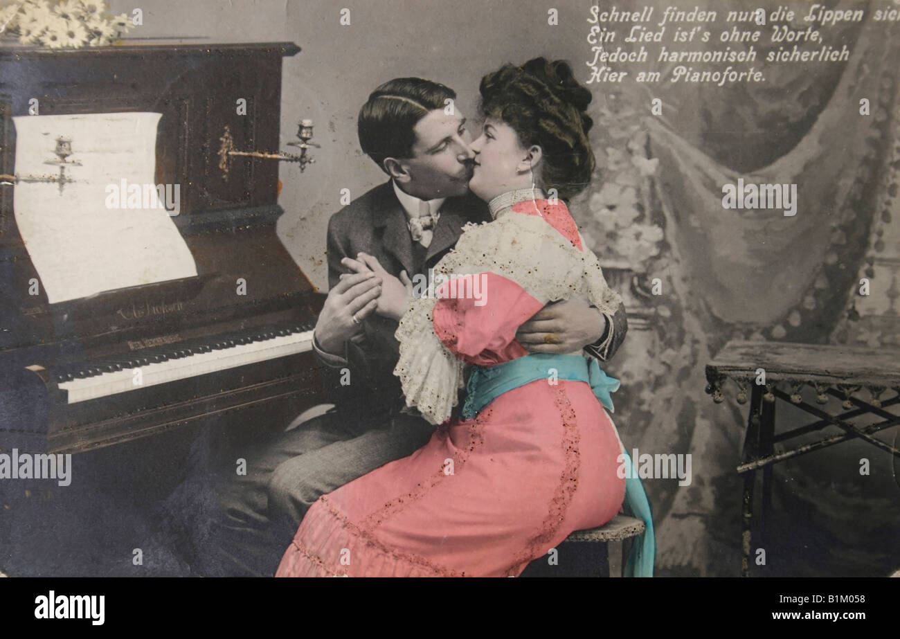 Deutsche alte Ansichtskarte aus dem Jahre 1909. Liebendes Paar küssen am Klavier mit text Stockfoto