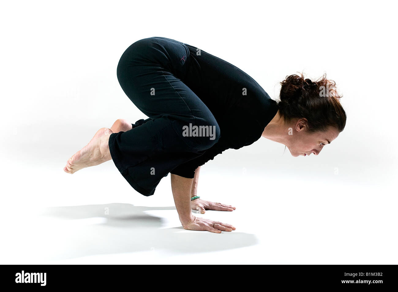 Höhenplan einer Frau üben die Krähe-pose Stockfoto