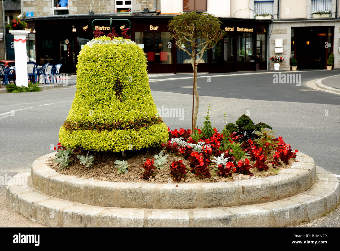 Ein Formschnitt Glocke in einem Blumenbeet in Villedieu Les Poêles, Normandie, Frankreich Stockfoto