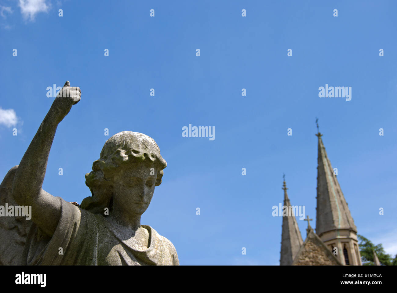 geschnitzte Engel mit erhobenem Arm und Türme der gotischen Kapelle am Friedhof von Teddington, Middlesex, england Stockfoto