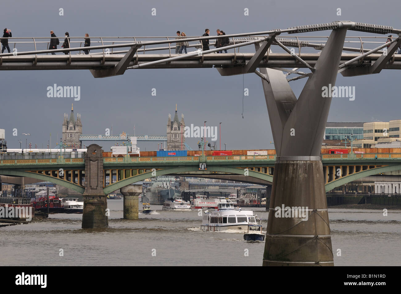 Menschen, die zu Fuß über die Millennium Bridge, mit Tower Bridge im Hintergrund Stockfoto