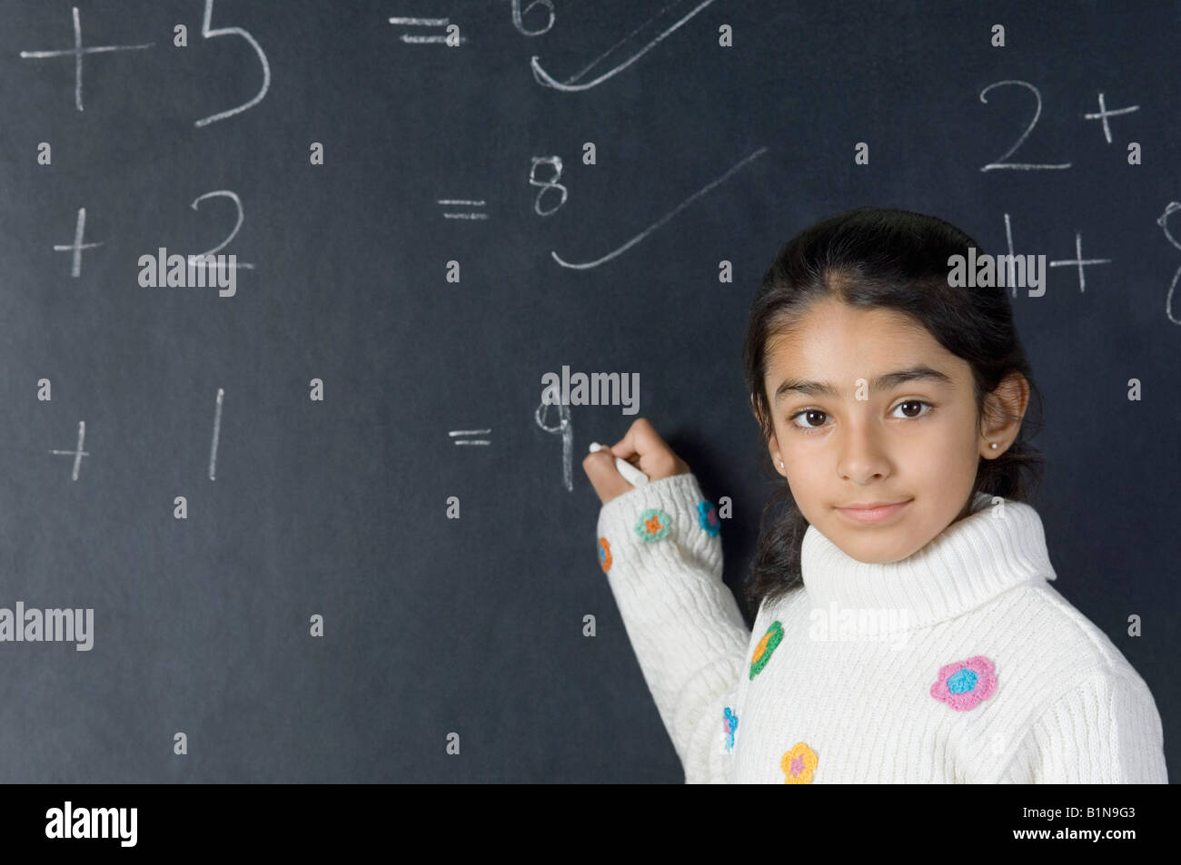 Porträt eines Mädchens, das lösen von mathematischer Symbolen auf einer Tafel Stockfoto