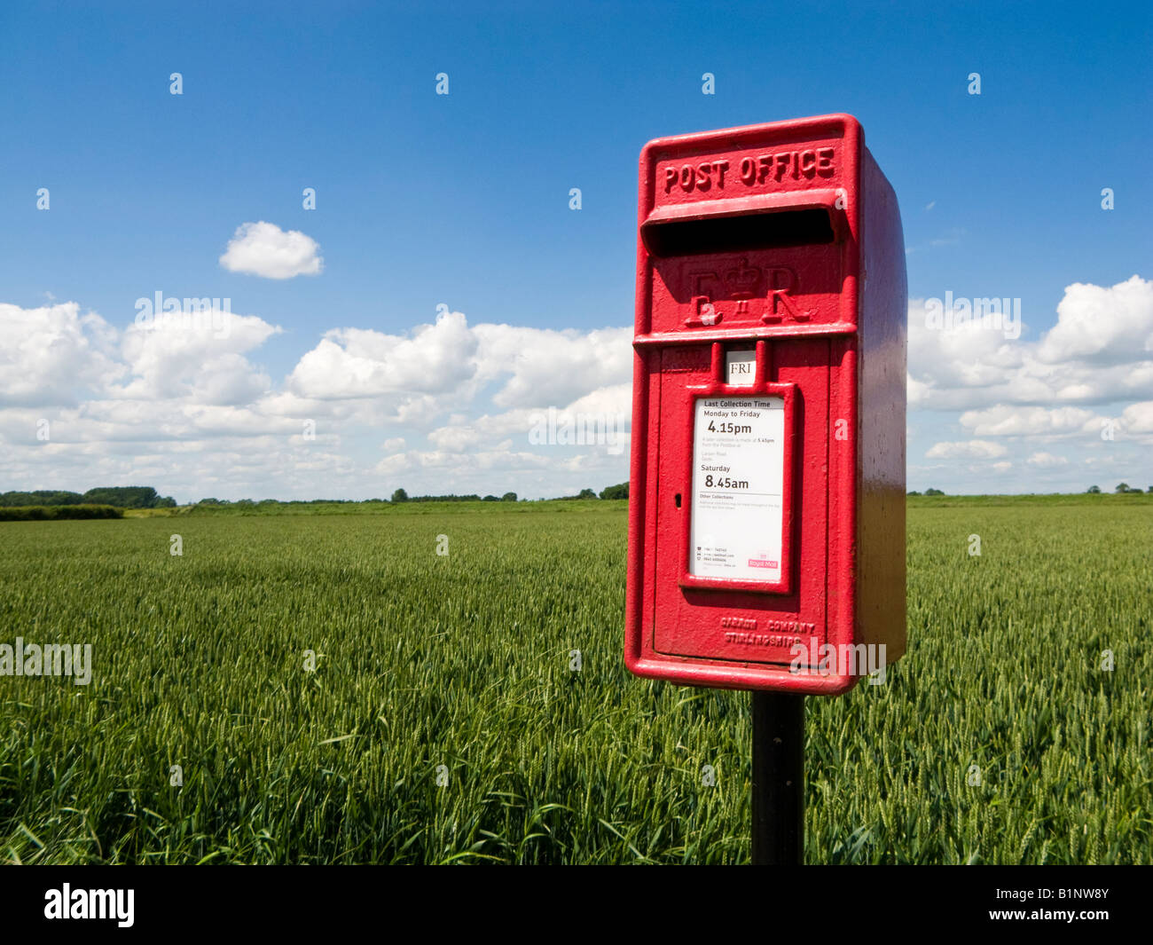 Ländliche rote Brieftasche oder Briefkasten auf dem Land neben einem Feld im Sommer England Großbritannien Stockfoto