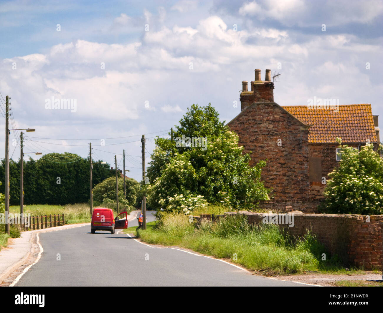 Post-Frau und rot Postamt van ländlichen Nachnahme Runde in East Yorkshire England UK Stockfoto