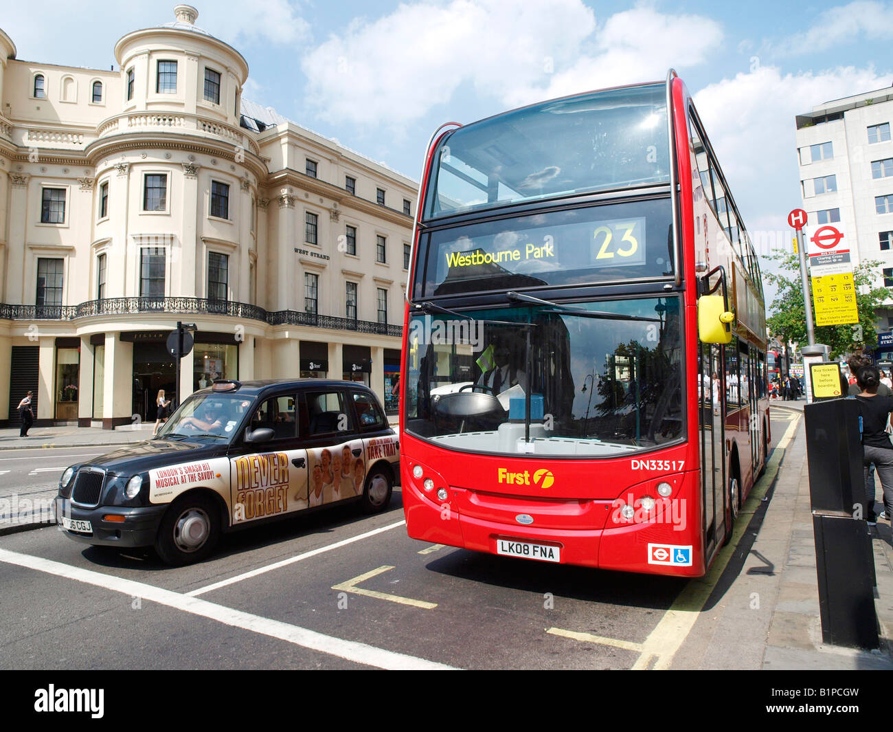 Bus und Taxi warten an der Ampel. Der Strang-London Stockfoto