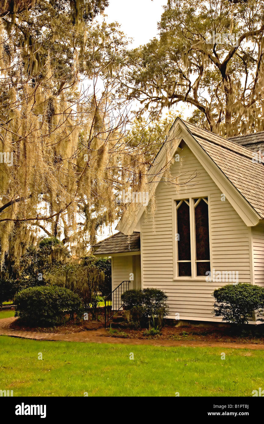 Eine alte kleine Kirche unter Eichen hängen mit spanischem Moos Stockfoto