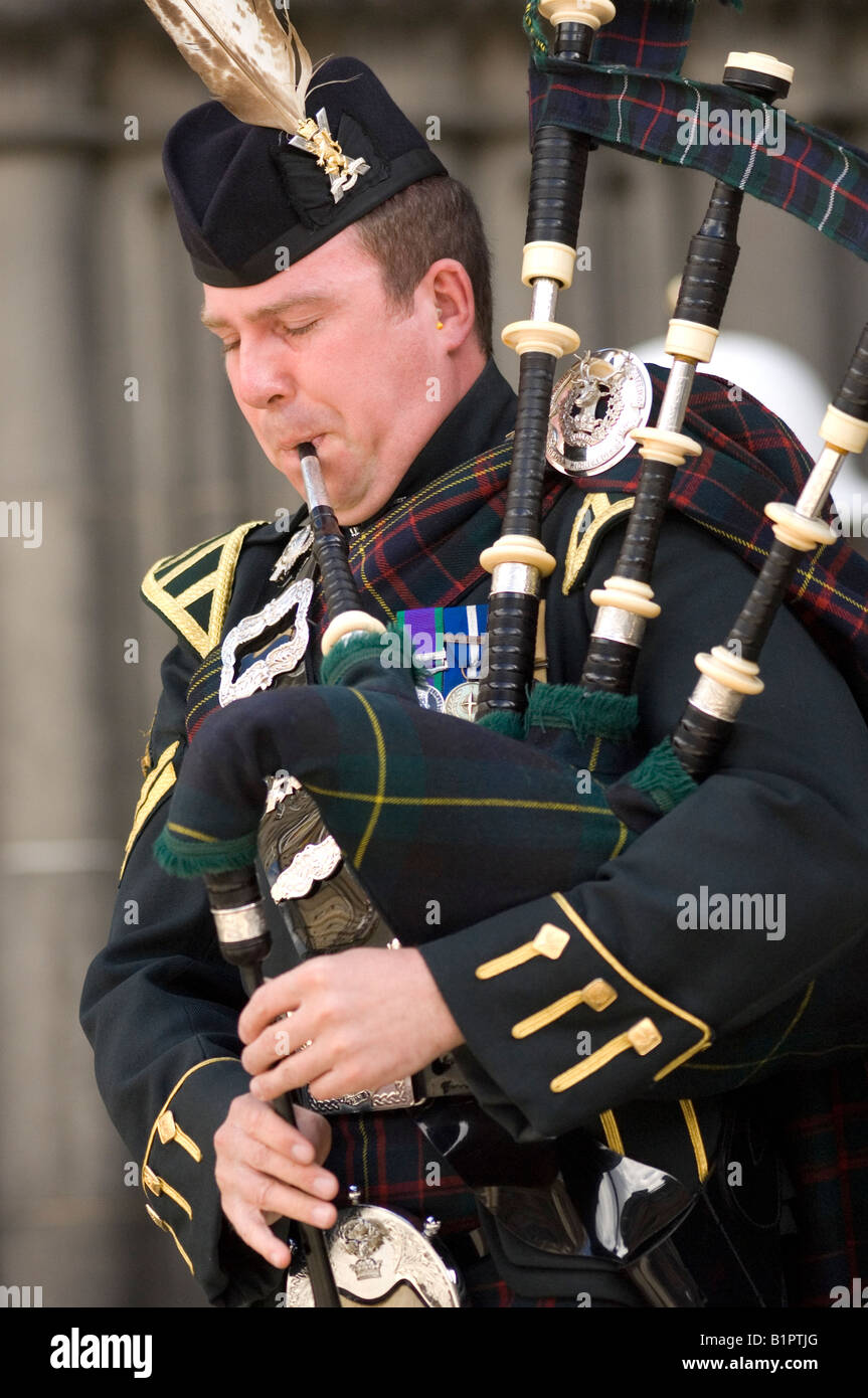 Eine Piper aus dem Royal Regiment Of Scotland spielt ein Klagelied auf dem Dudelsack außerhalb St Giles' Cathedral in Edinburgh. Stockfoto