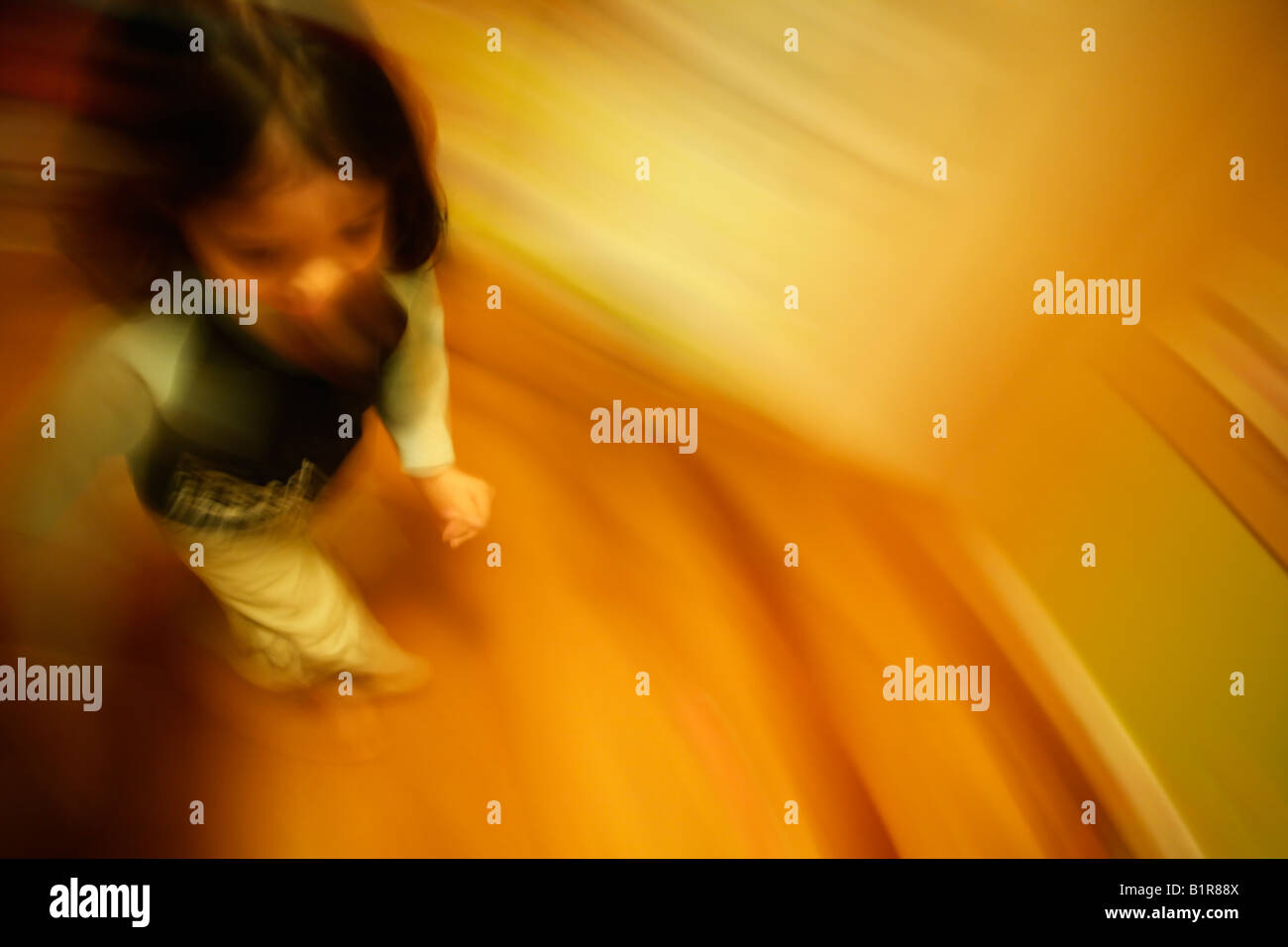 Absichtliche Langzeitbelichtung mit Kamera und Motiv Bewegung erstellen abstraktes Bild Mädchen im Alter von vier Jahren läuft auf ihrem Zimmer Stockfoto