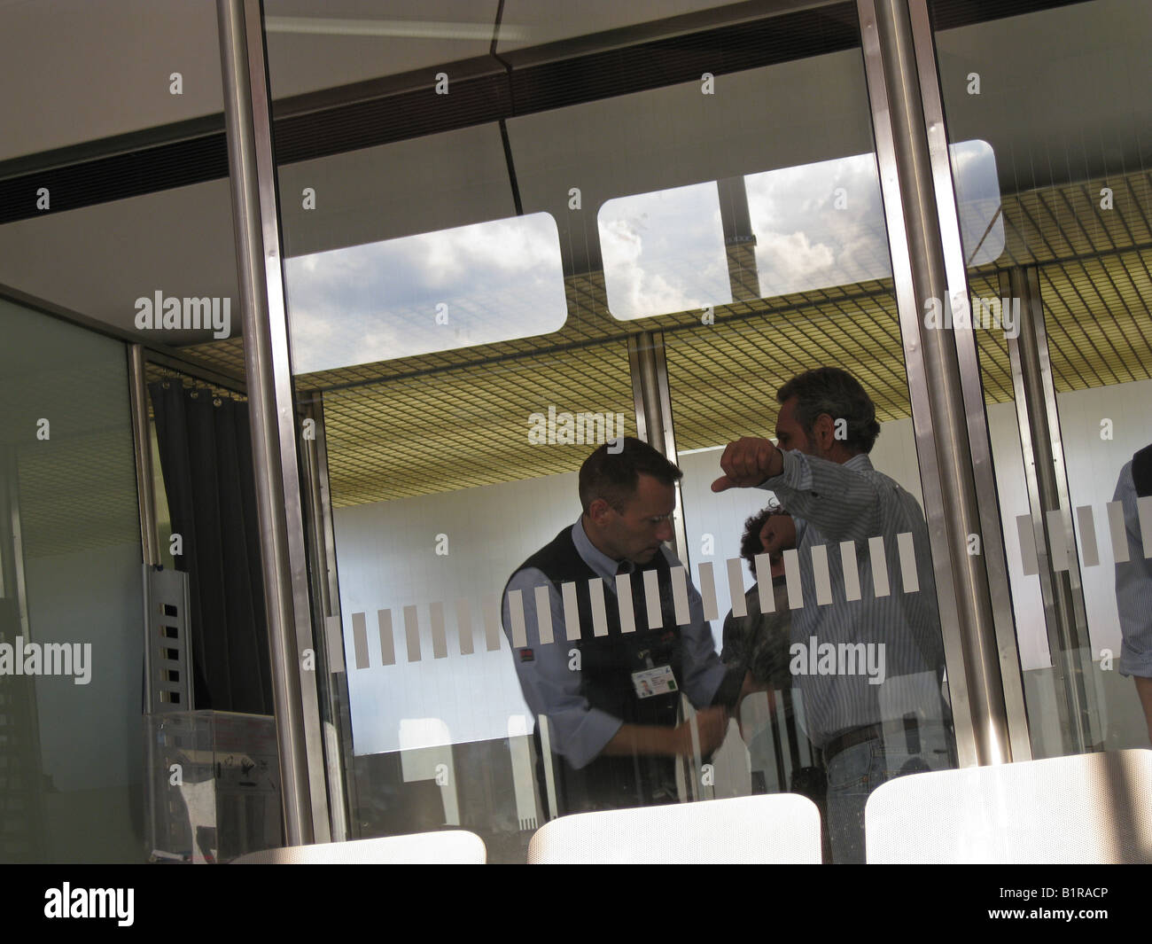 Passagiere werden vom Sicherheitsmann am Internationalen Flughafen Berlin-Deutschland überprüft Stockfoto