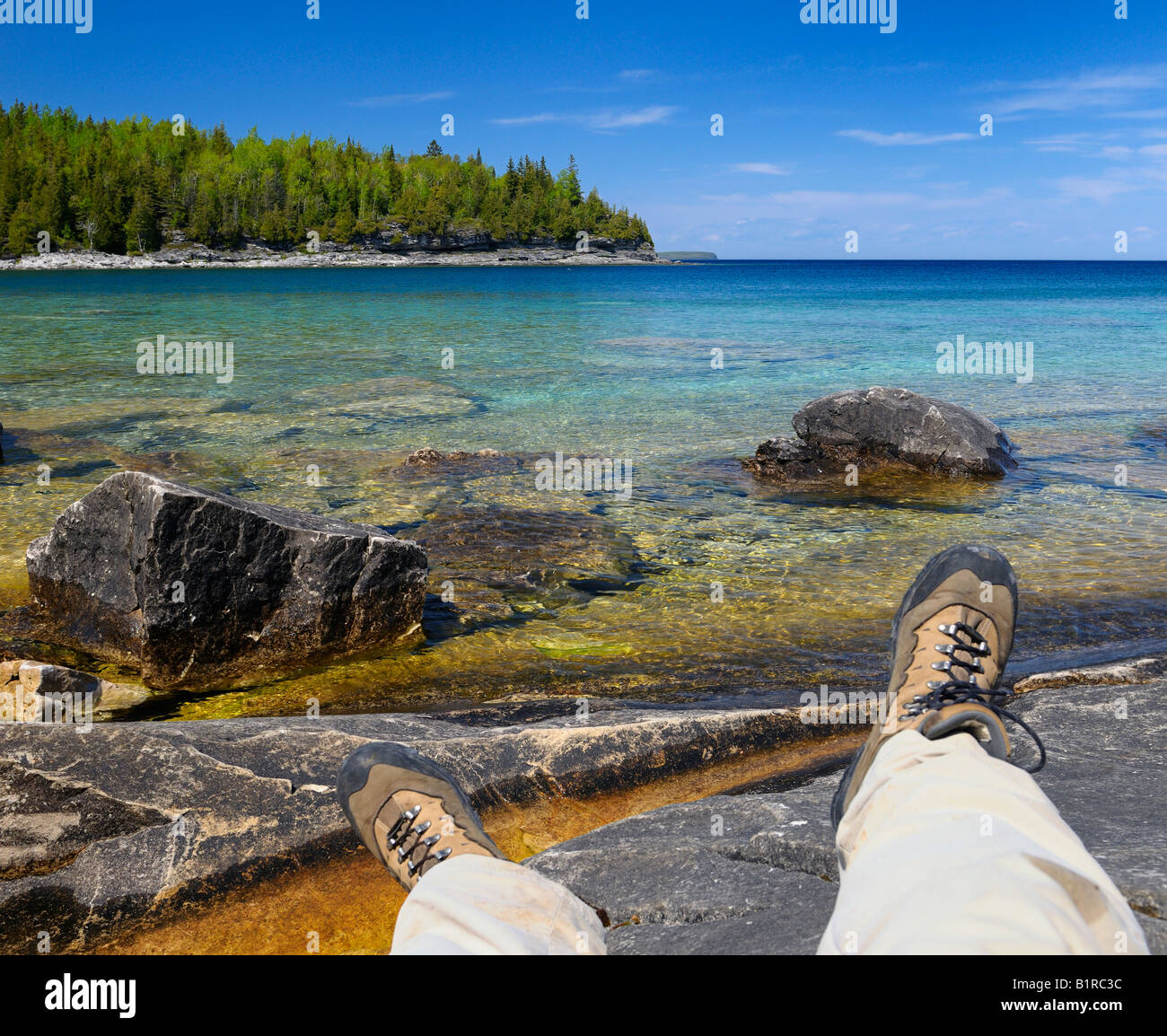 Wanderer-Füße entspannen am felsigen Ufer der kleinen Bucht in der Bruce Peninsula Georgian Bay Ontario Stockfoto