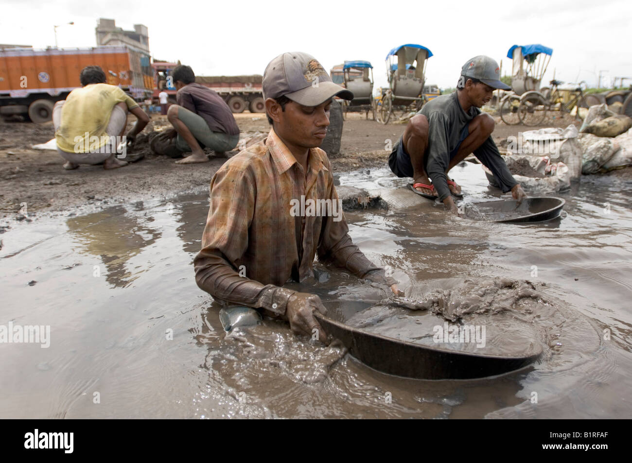 Indische Tagelöhner mit Sortierung Kupfer Splitter von toxischen industriellen Schlacke, verdienen ihren Lebensunterhalt aus dem recycling von Abfällen in der slu Stockfoto