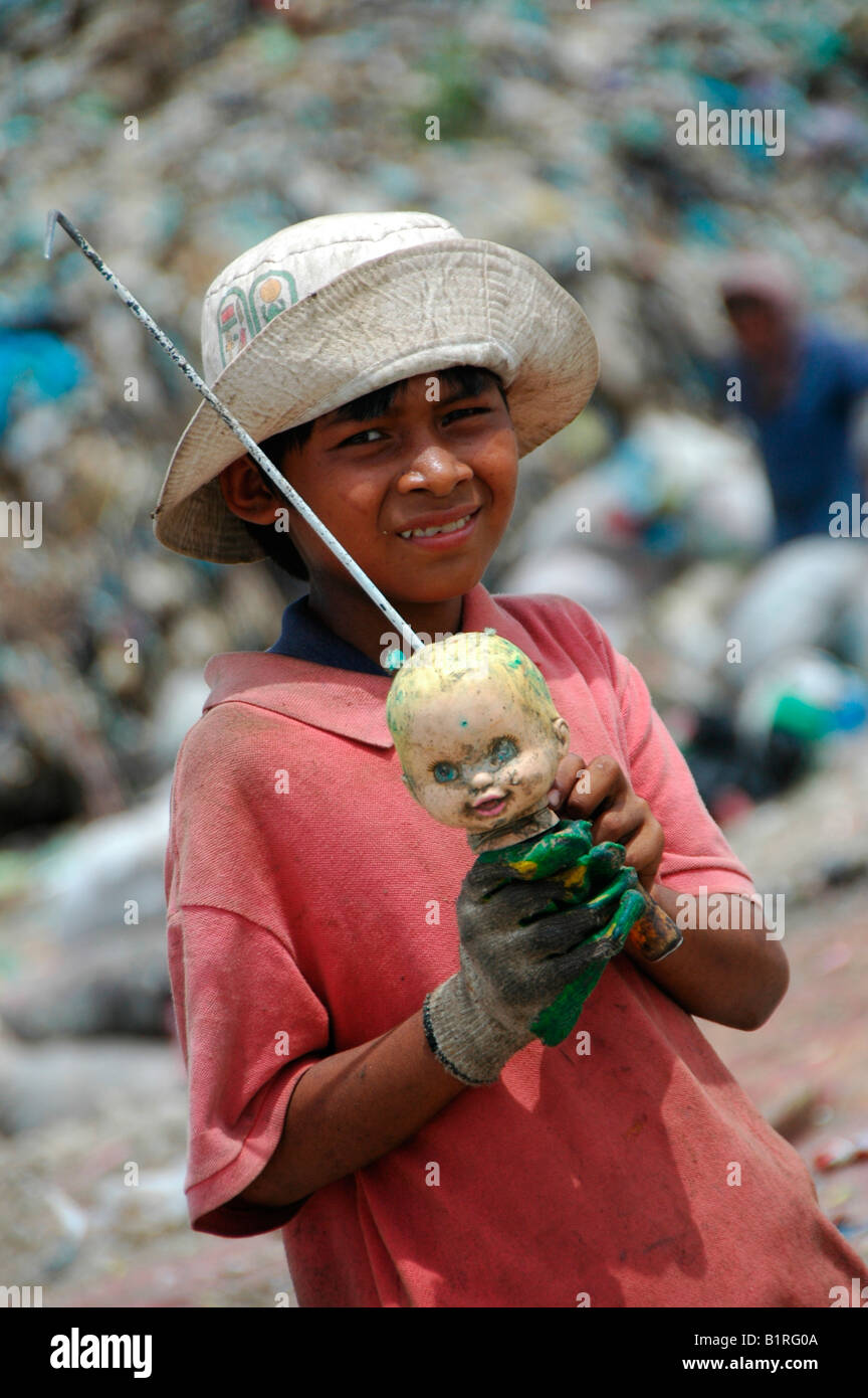 Kind beim Stöbern durch eine Müllhalde findet eine Puppen-Kopf auf der Stung Meanchey kommunalen Mülldeponie im Süden von Kambodscha Stockfoto
