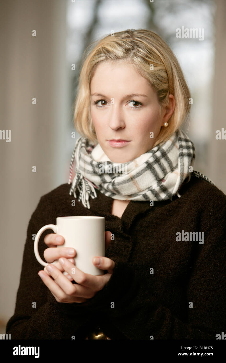 Blonde Frau mit einer Tasse Tee und einen Schal Stockfoto