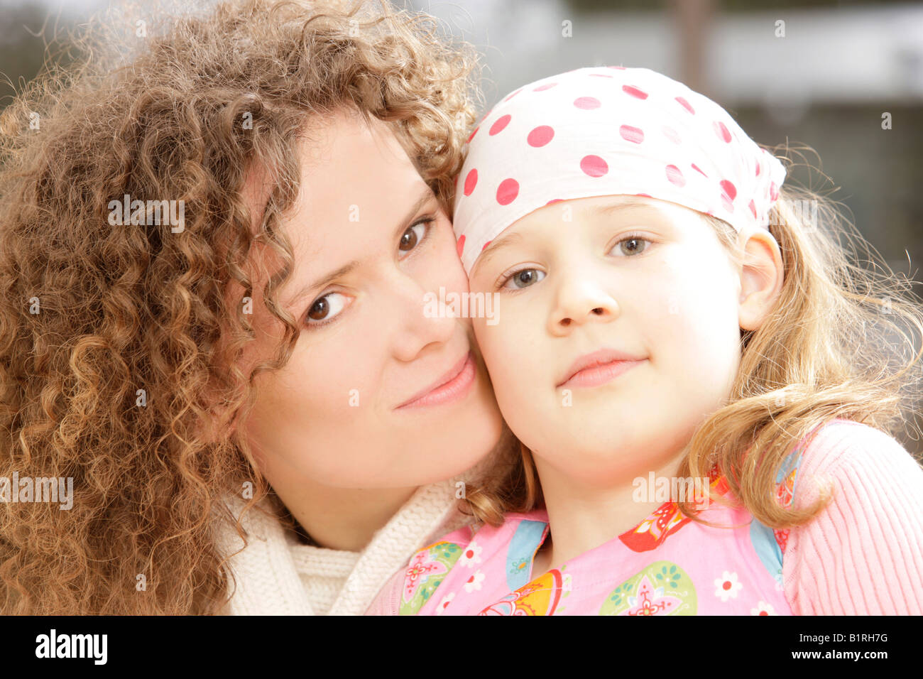 Mutter mit lockigem Haar und ihre Tochter, 8 Jahre alt Stockfoto