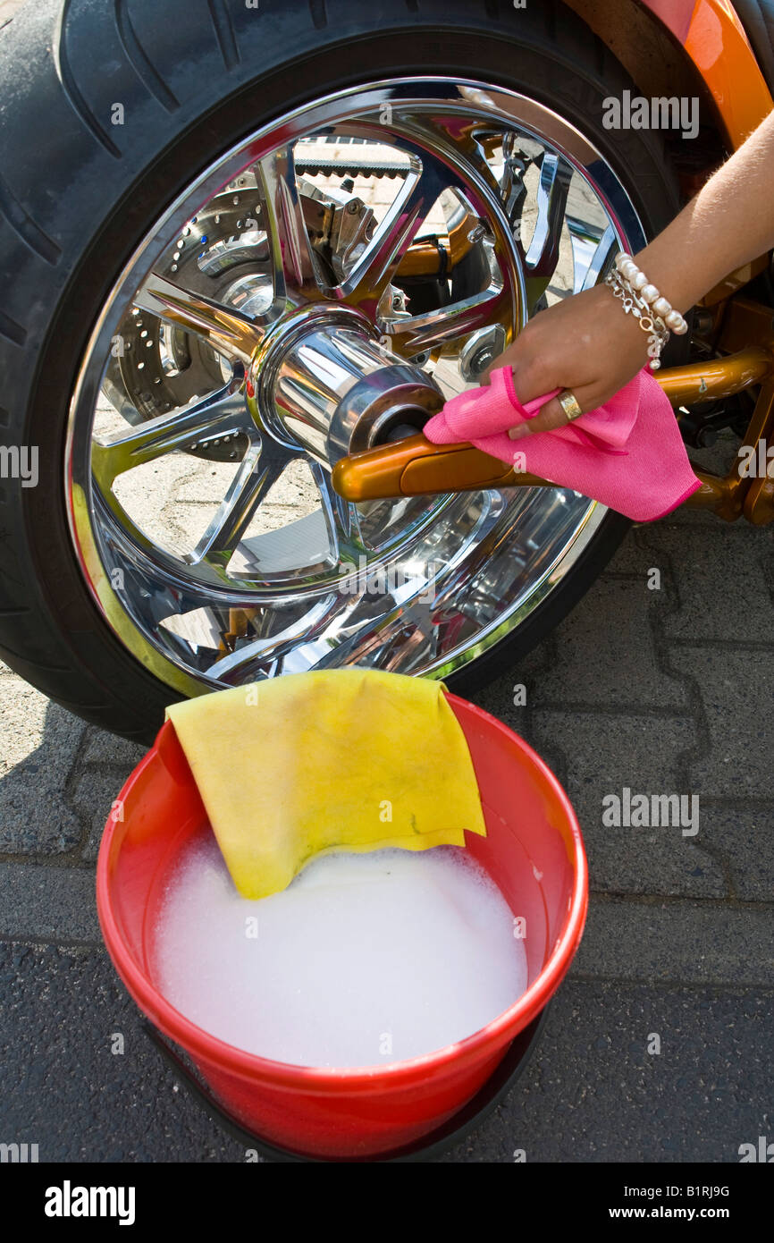 Frau, die ein Motorrad waschen Stockfoto
