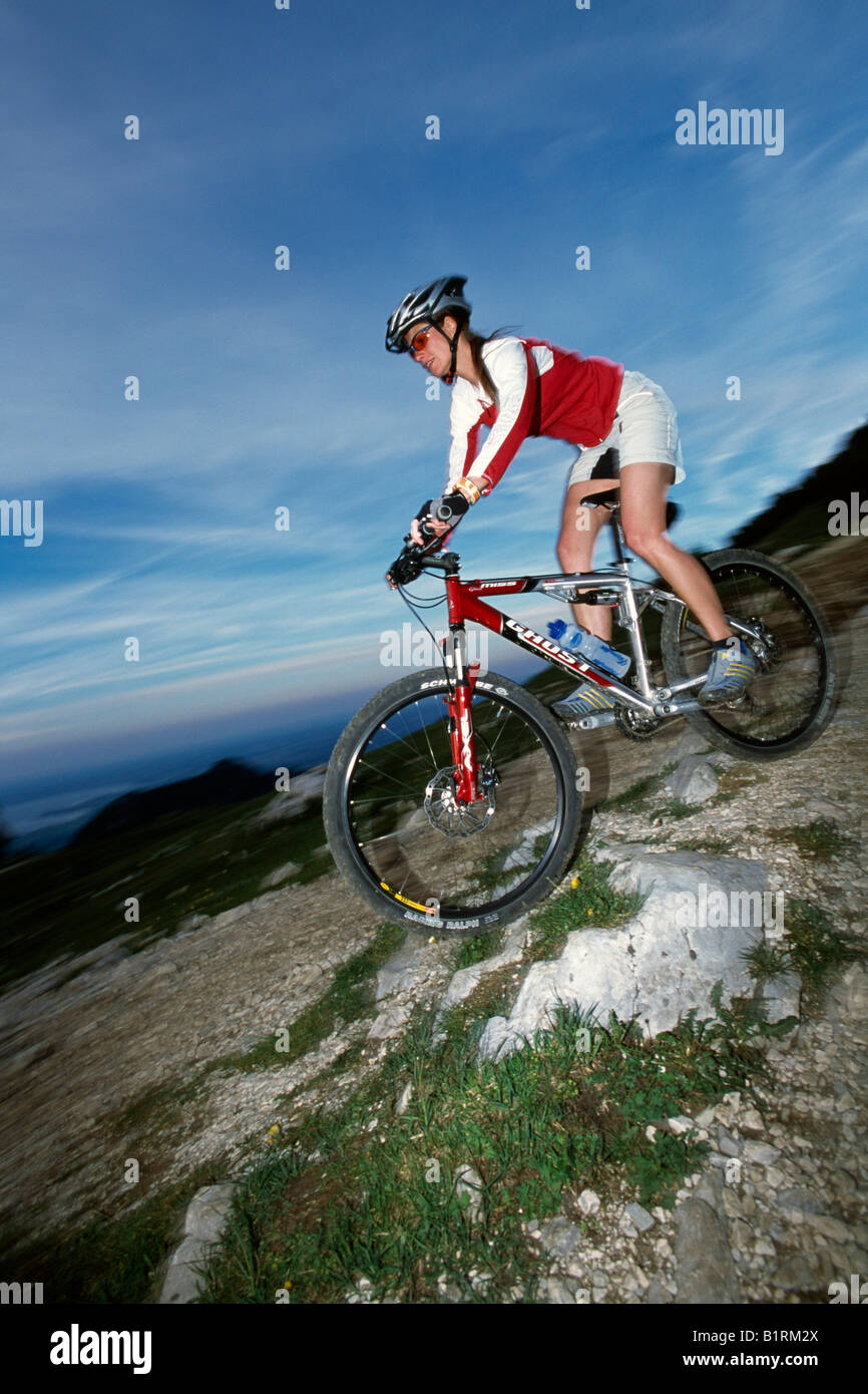 Weibliche Mountainbiker fährt bergab Stockfoto