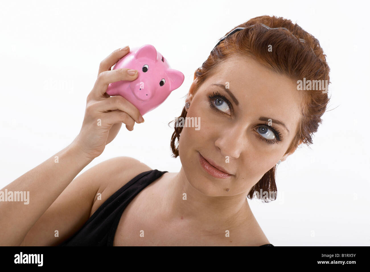 Frau ein Sparschwein anhören Stockfoto