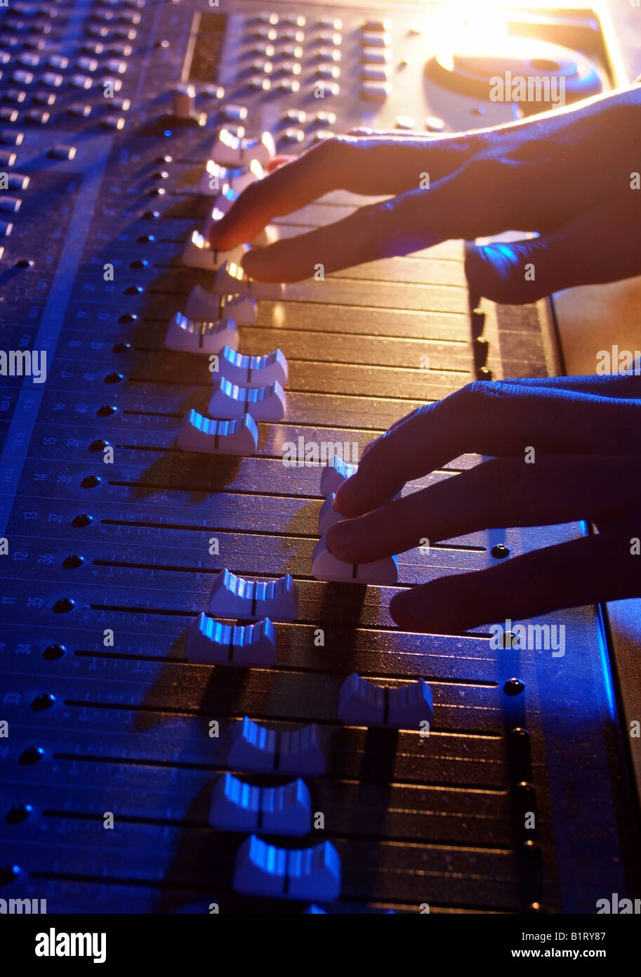 Händen der Tontechniker anpassen die Regulatoren von einer professionellen Mixer-Einheit Stockfoto