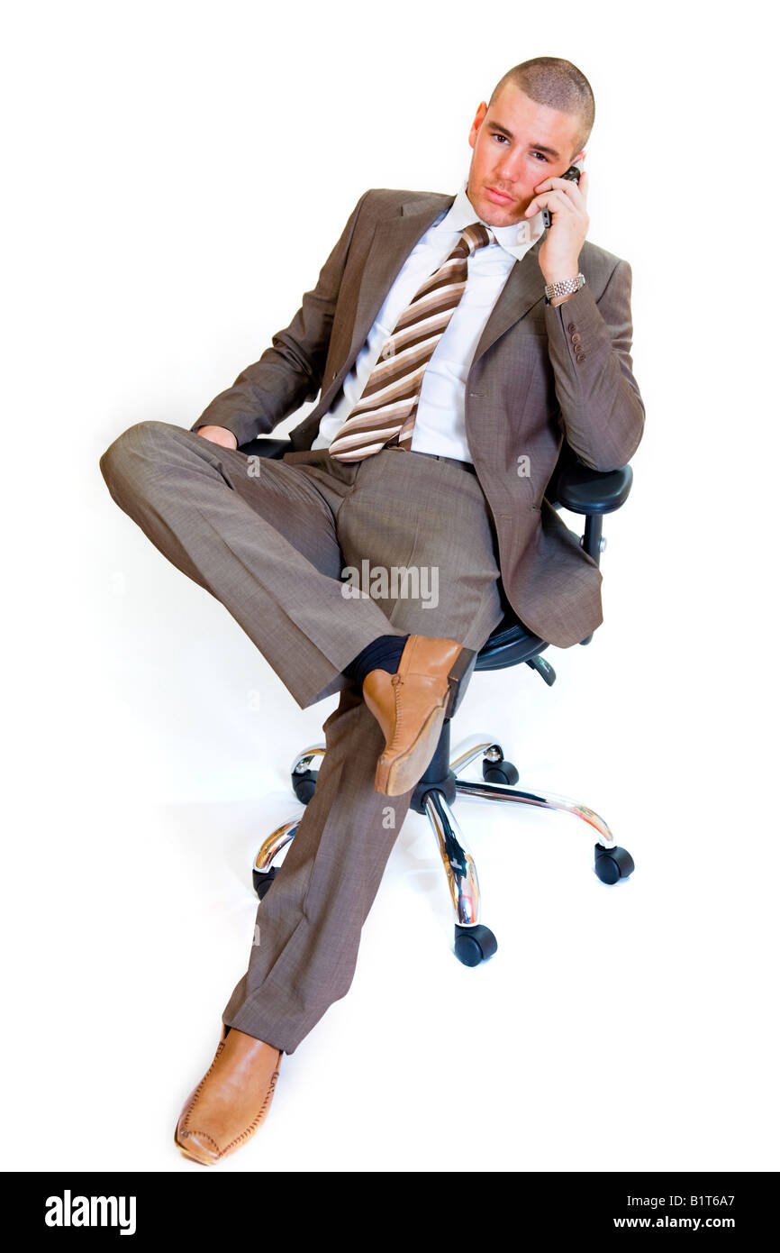Junge Unternehmer sitzen auf einem Bürostuhl mit dem Handy telefonieren. Stockfoto