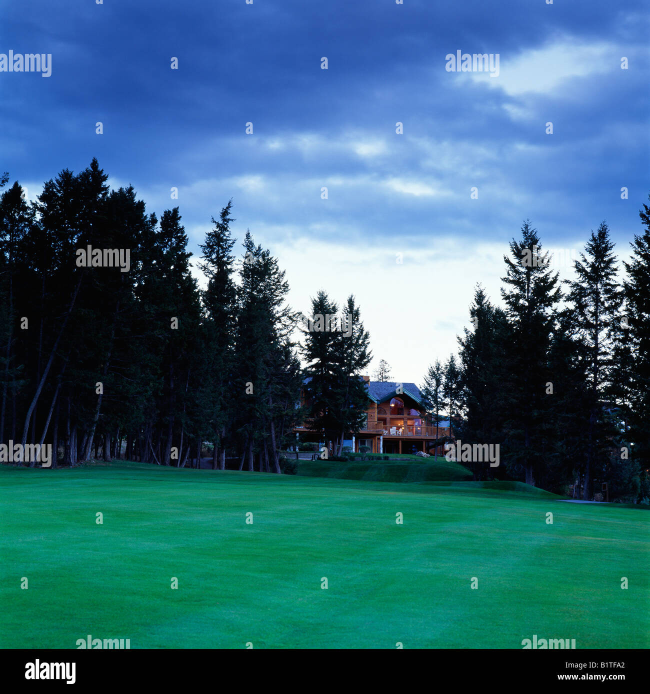Privathaus in der Abenddämmerung mit Blick auf Berg Golf Course, Fairmont Hot Springs, Britisch-Kolumbien, Kanada Stockfoto