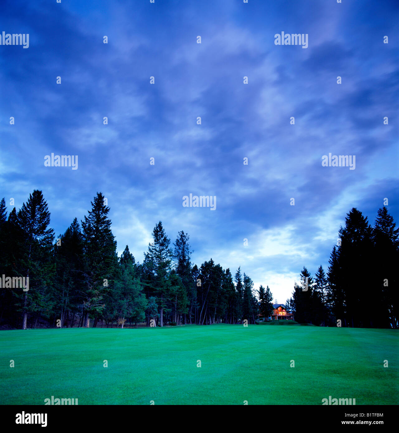 Privathaus in der Abenddämmerung mit Blick auf Berg Golf Course, Fairmont Hot Springs, Britisch-Kolumbien, Kanada Stockfoto