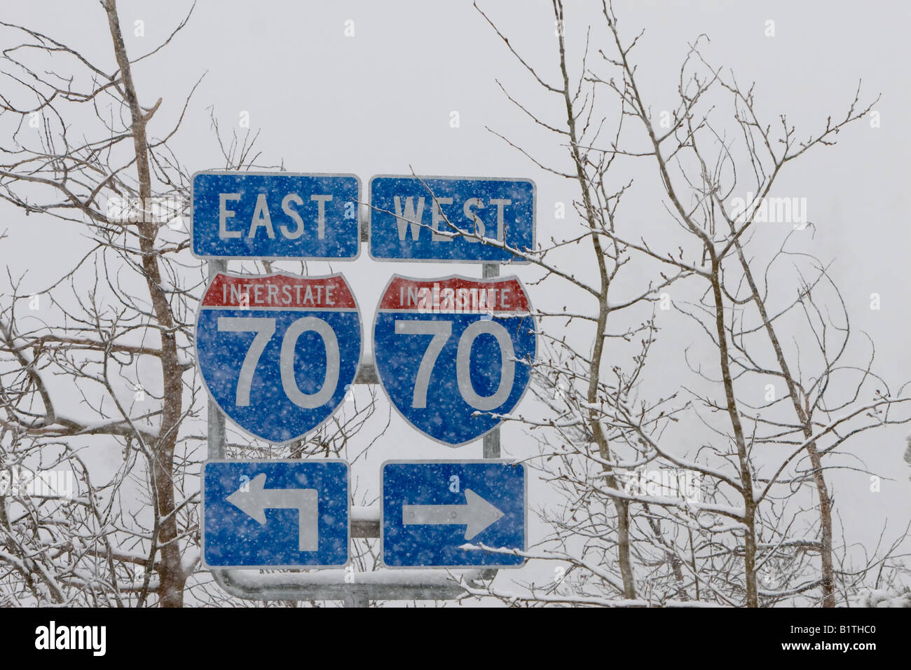 Ein Schneesturm verdunkelt die Zeichen für Interstate Highway 70 in den Bergen von Colorado. Stockfoto