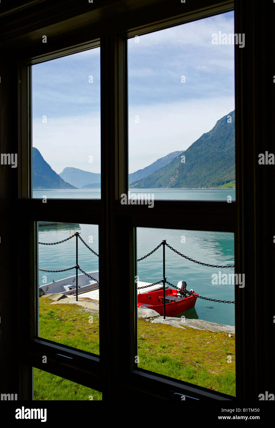 Ein Blick aus dem Fenster der zwei Ruderboote festgemacht auf einem Steg über den Sognefjord, Skjolden, Norwegen. Stockfoto