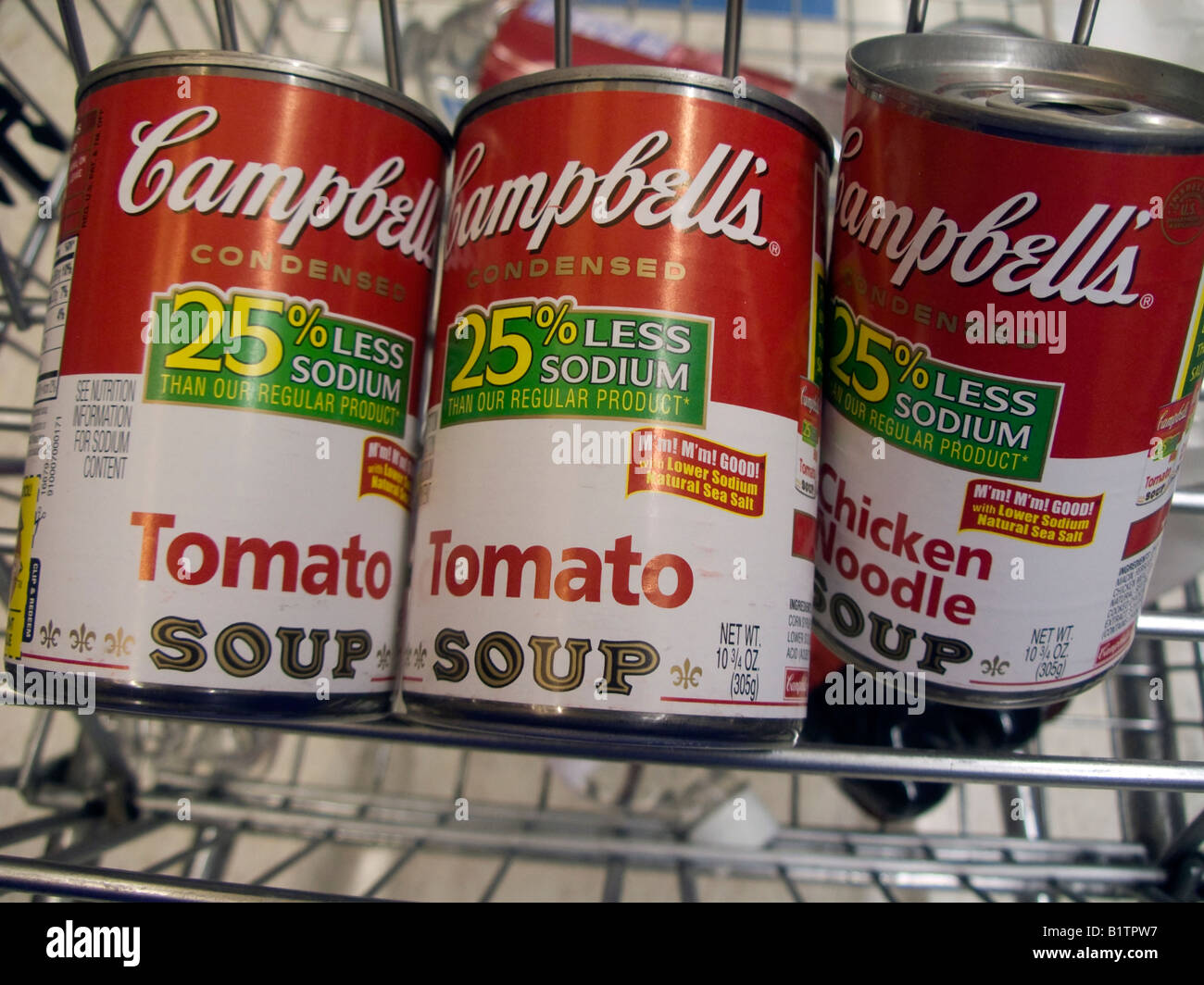 Dosen von Campbell s Tomaten und Hühnchen Nudelsuppe in einem Lebensmittelgeschäft Wagen in einem Supermarkt in New York zu sehen sind Stockfoto