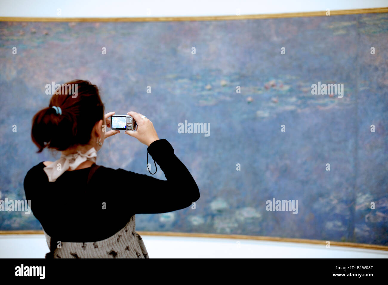 Frau mit Digitalkamera in Galerie, Orangerie, Paris Stockfoto