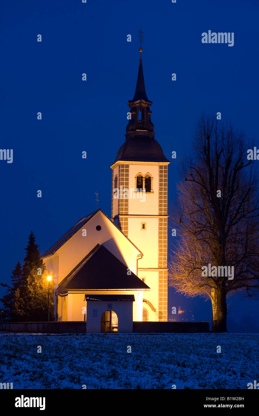 Kirche in der Nacht im Winter auf einem Feld am Rand einer kleinen Stadt in Slowenien Stockfoto