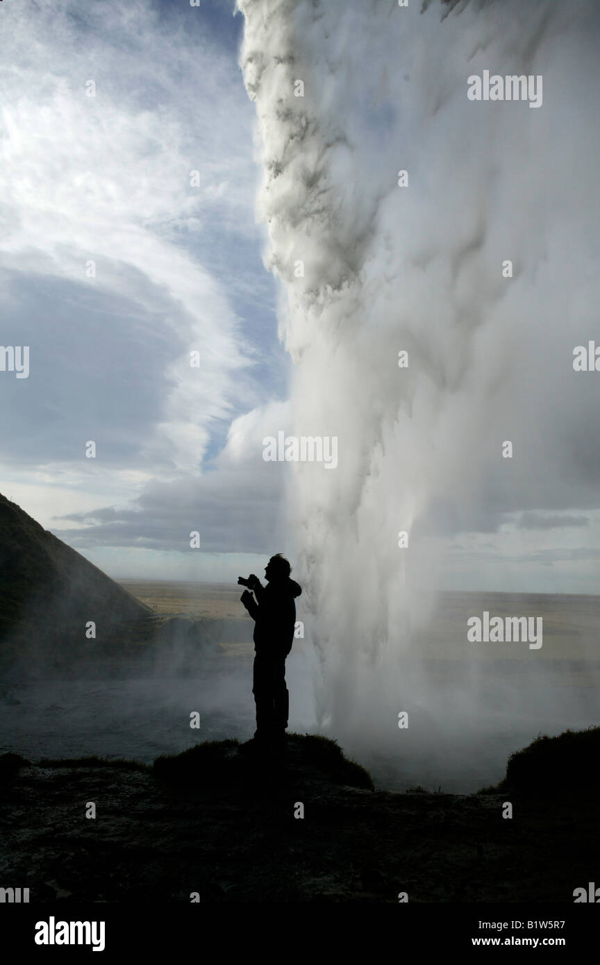 Mann unter Foto hinter Wasserfall Seljalandsfoss, Island Stockfoto