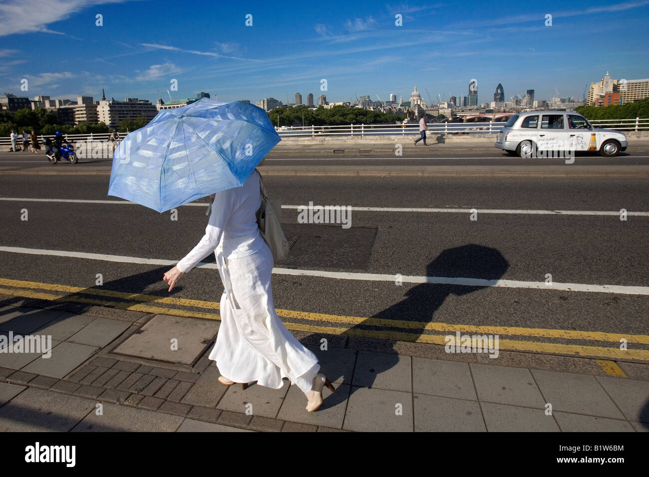 eine Frau mit einem Sonnenschirm auf Waterloo Bridge, london Stockfoto