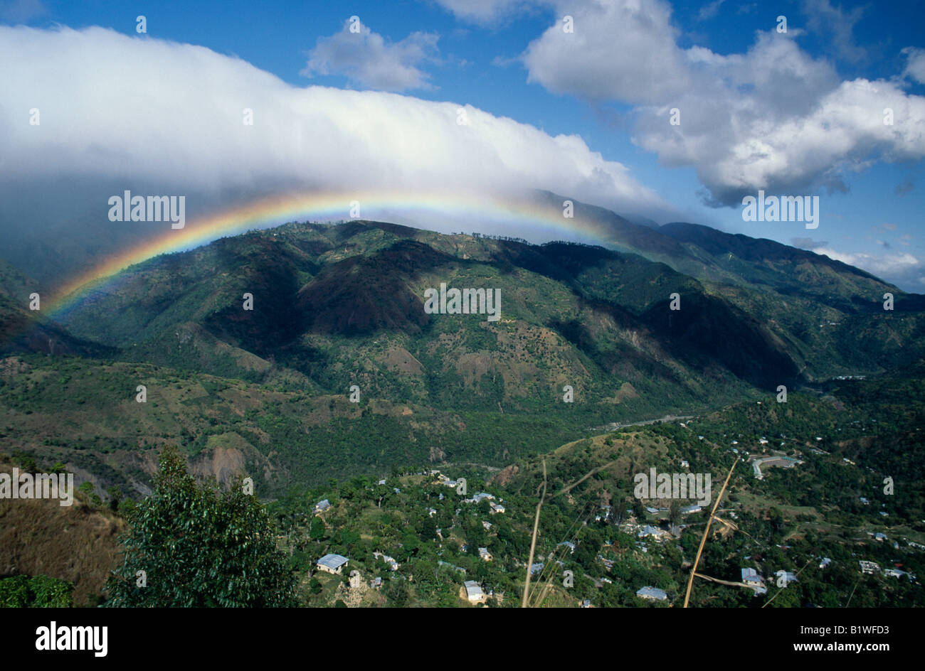 Gebirgslandschaft mit Regenbogen und Abweichungen der Wolke. Stockfoto