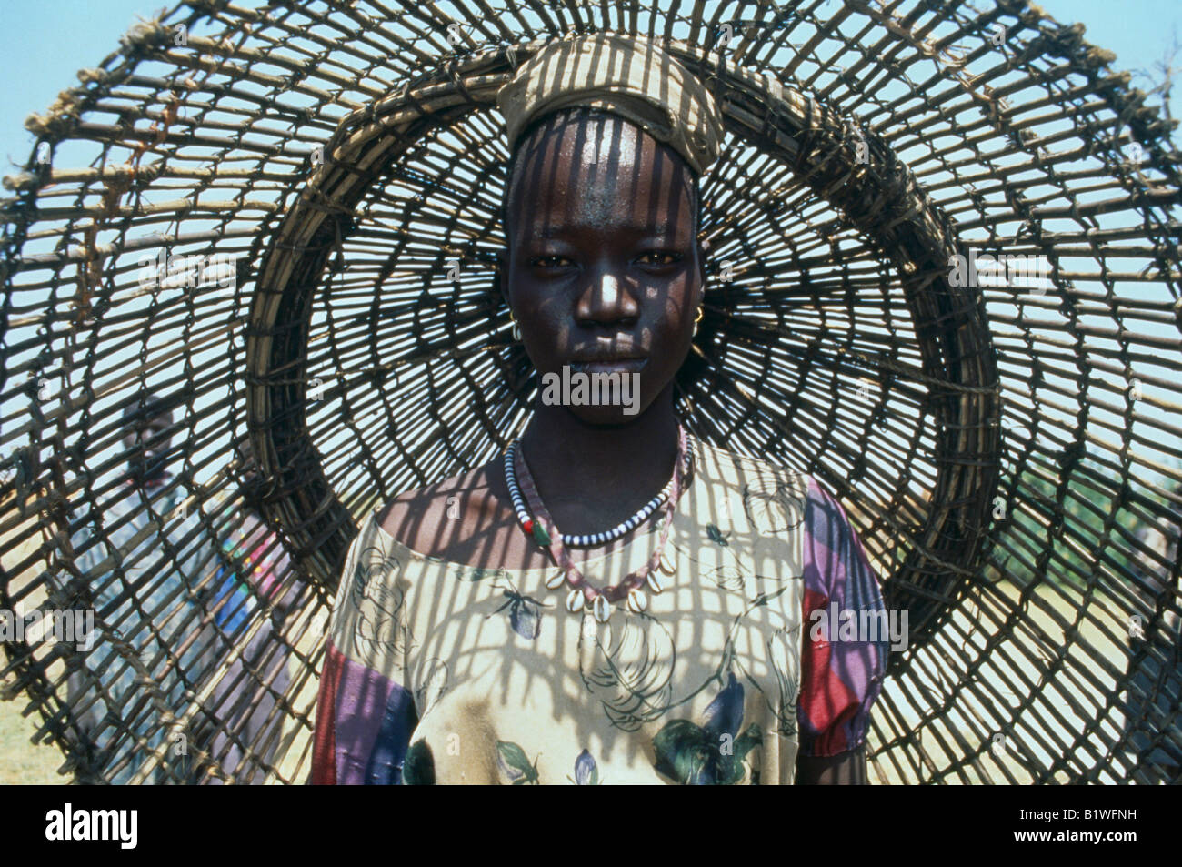 SUDAN Nordafrika Bahr El Ghazal Porträt jungen Dinka-Frau mit Fischen Korb hinter ihrem Casting Schatten Muster auf Ihr Stockfoto