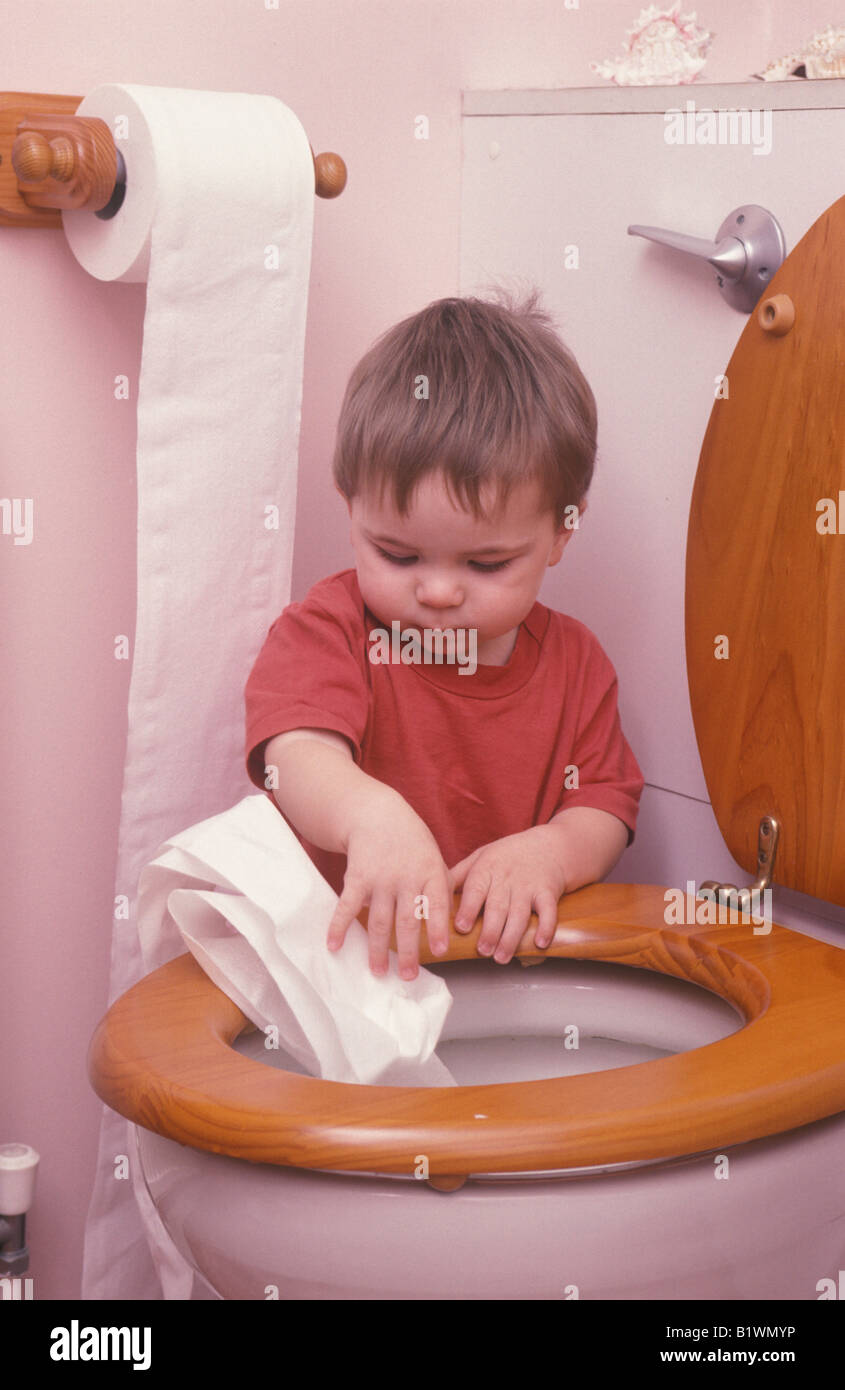 kleiner Junge spielt mit Toilettenpapier im Bad Stockfoto