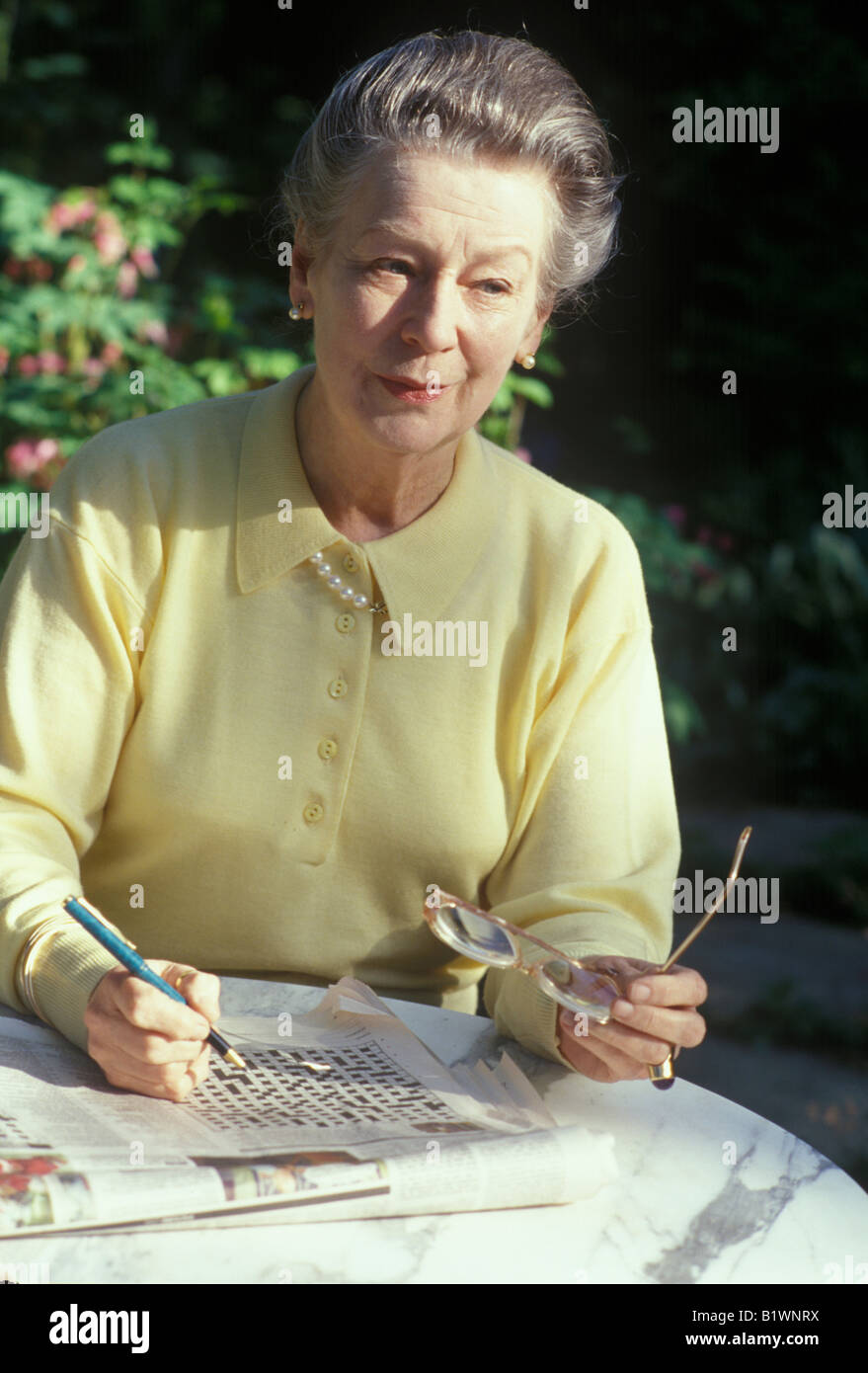 ältere Frau tut das Kreuzworträtsel, mental wachsam zu halten Stockfoto