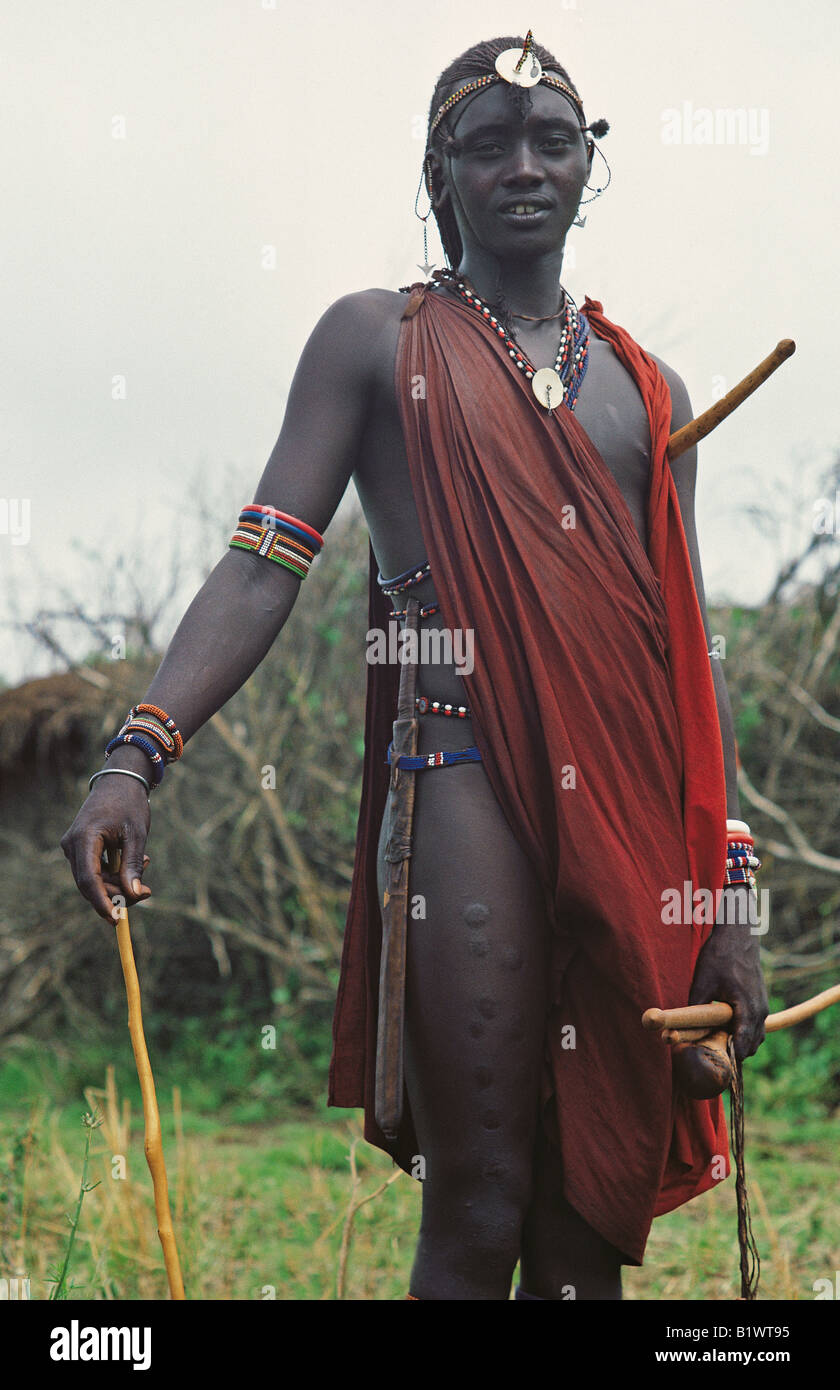 Moran Massai-Krieger in Perlen und roten Shuka zeigen Narben am Bein verursacht durch Verbrennungen Tapferkeit gegen Schmerzen Kenia in Ostafrika Stockfoto