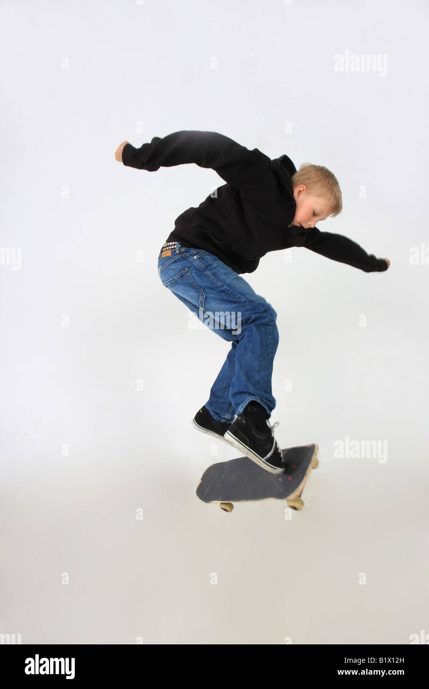 Skateboarder machen einen Kickflip mit seinem Schuss in Begleitung an Bord und isoliert auf weiss Stockfoto