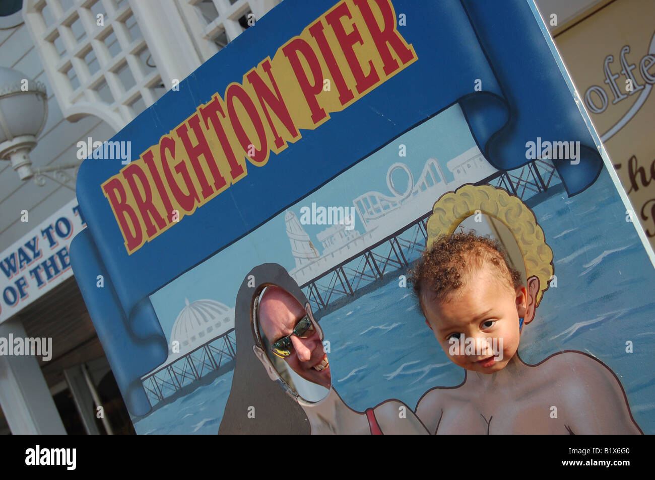 Zwei Menschen stecken ihre Köpfe durch ein Rummelplatz-Board, Pier von Brighton England Stockfoto