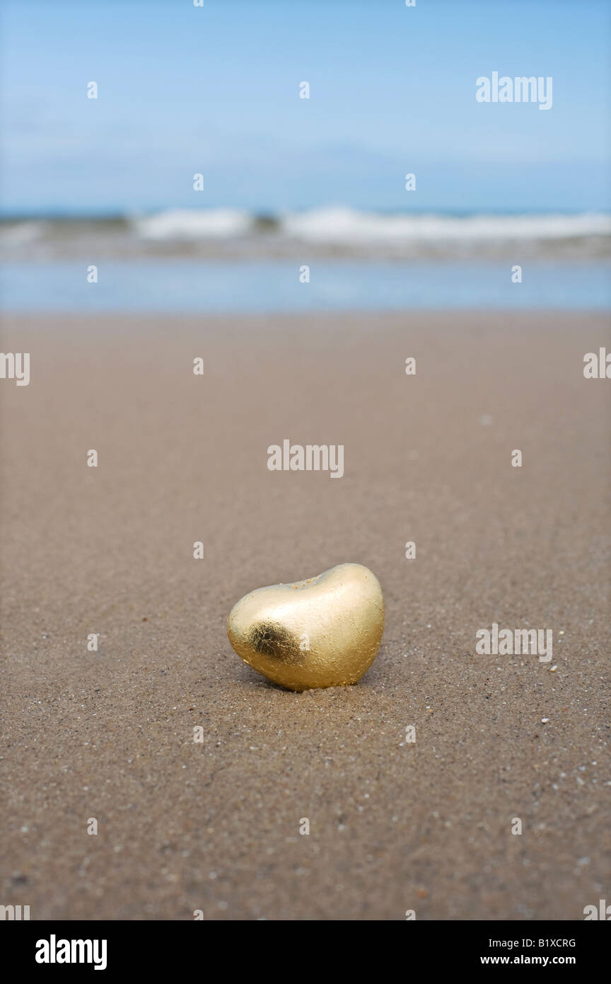 Goldenes Herz geformte Kiesel am Strand von Findhorn, Schottland Stockfoto