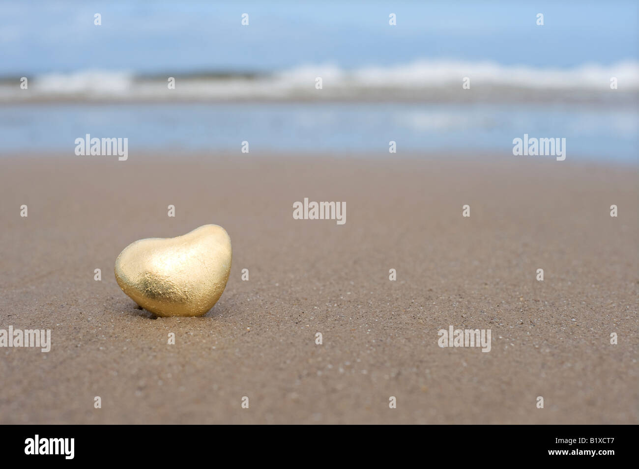 Goldenes Herz geformte Kiesel am Strand von Findhorn, Schottland Stockfoto